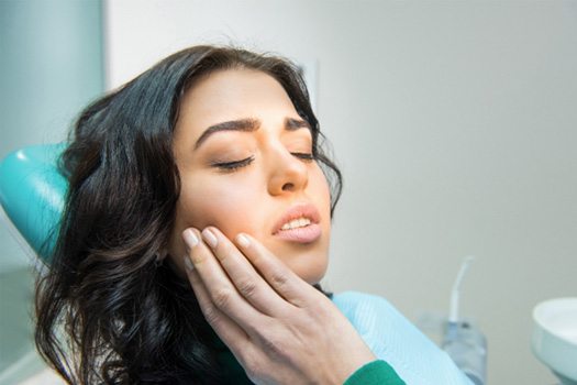 Patient in Madison rubbing jaw due to TMJ issues