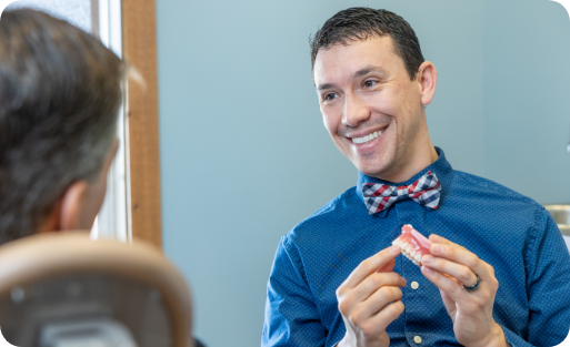 Doctor Parry showing a model of a row of teeth to a patient